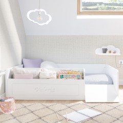 Letto Montessori bianco con contenitore giocattoli e rampa.